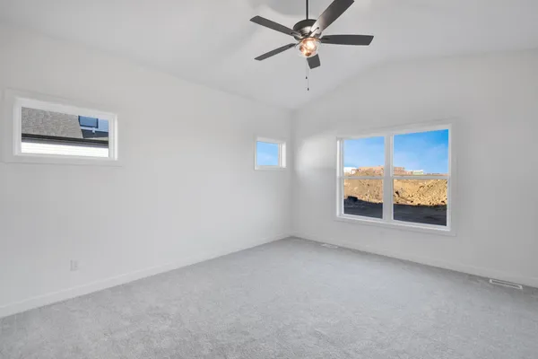 an empty room with windows and fan