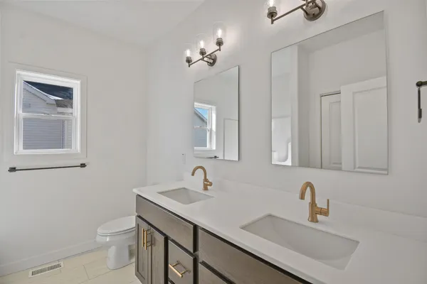 a bathroom with a toilet a sink a mirror and vanity
