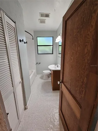 a bathroom with a sink a toilet and a mirror