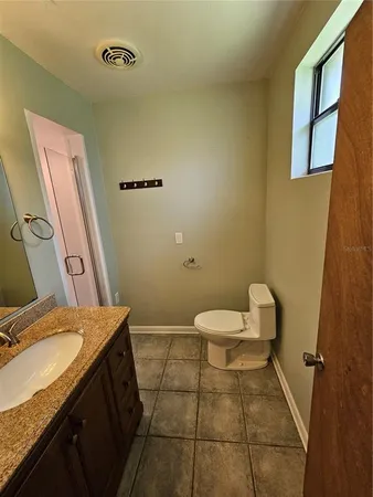 a bathroom with a granite countertop sink toilet and shower