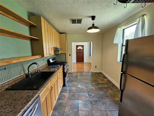a kitchen with a sink a refrigerator and a stove