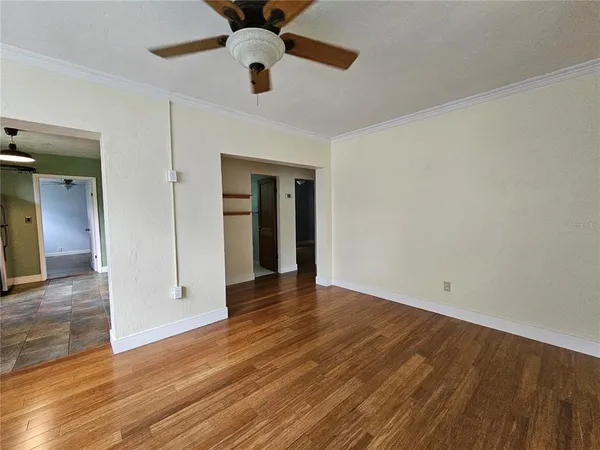 a view of an empty room with wooden floor