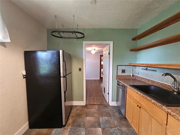 a kitchen with stainless steel appliances granite countertop a refrigerator and a sink