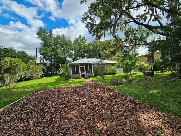 a view of backyard of house with green space