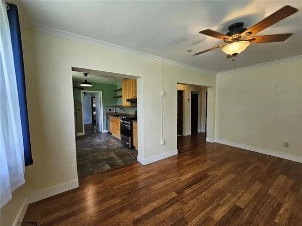 a view of a livingroom with wooden floor and a ceiling fan
