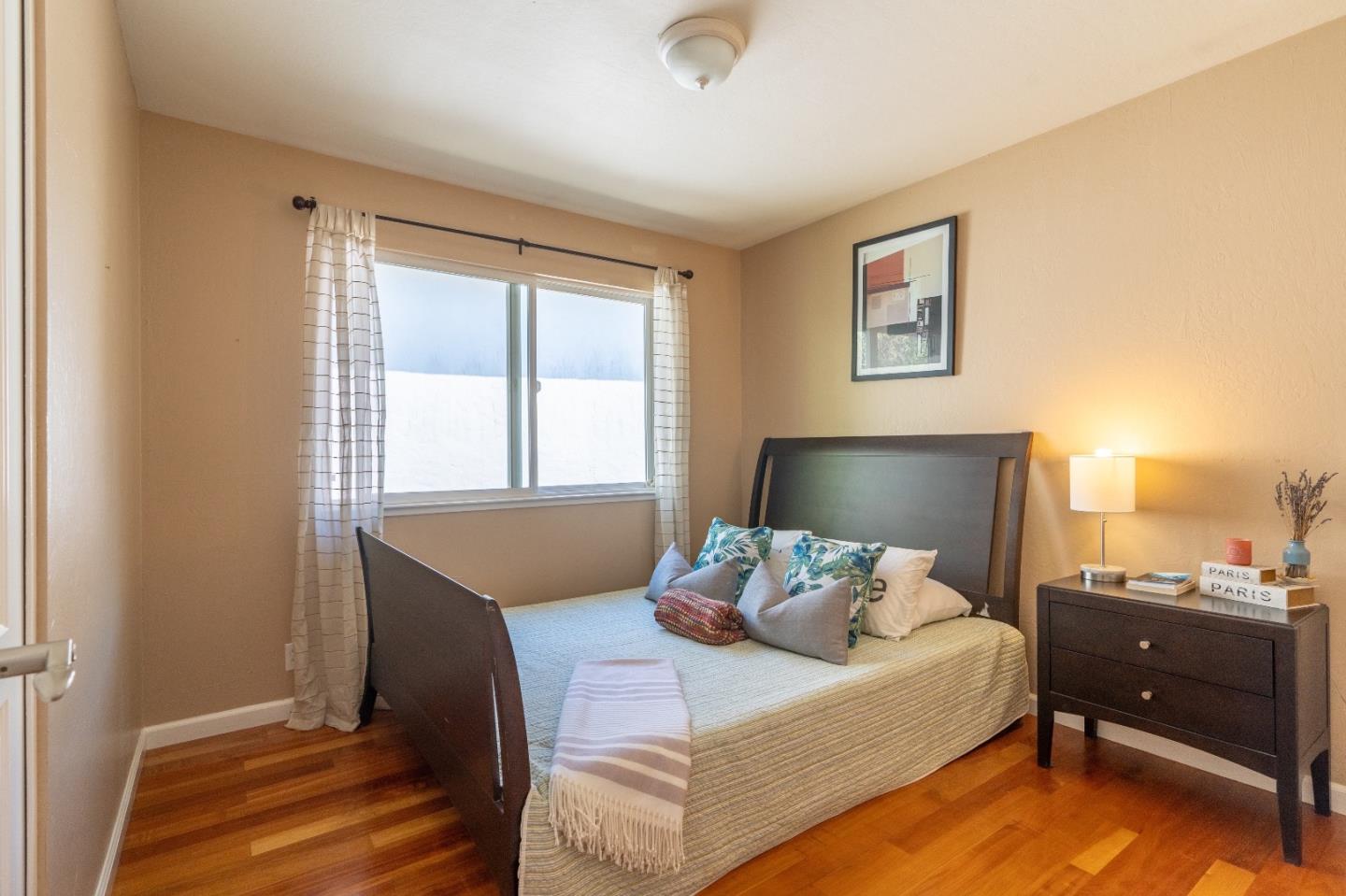 815 Cape Breton Drive Pacifica, CA 94044 - Photo 32 of 65 a bedroom with a bed and wooden floor