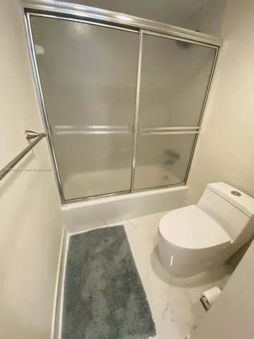 a bathroom with a toilet and a shower