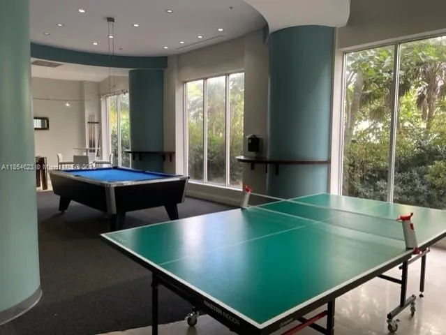 a room with pool table and windows