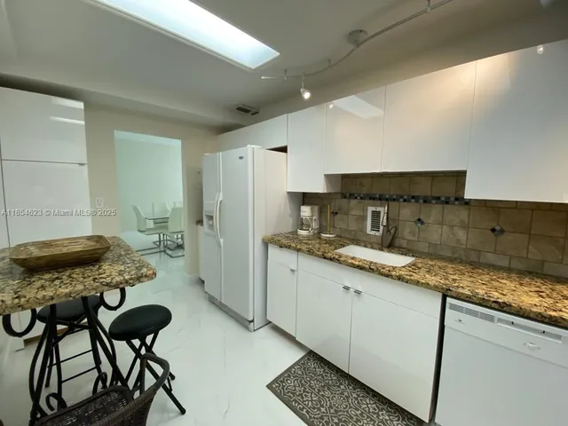 a kitchen with stainless steel appliances granite countertop sink stove top oven and cabinets