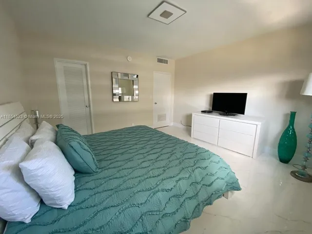 a bedroom with a bed and a television