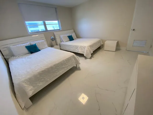 a bedroom with two beds and lamp