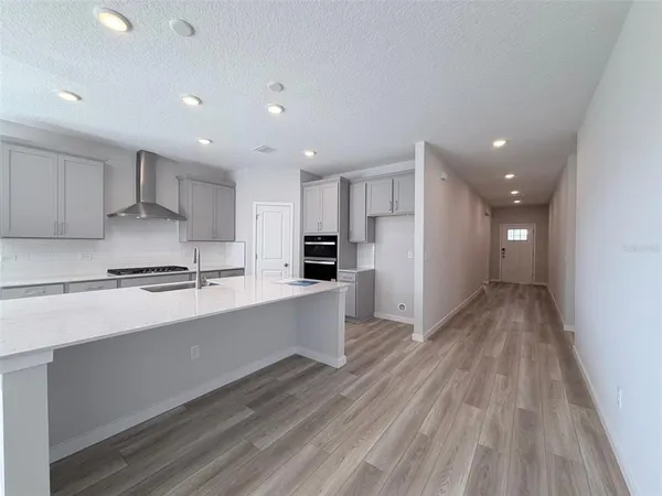 a kitchen with white cabinets and black appliances
