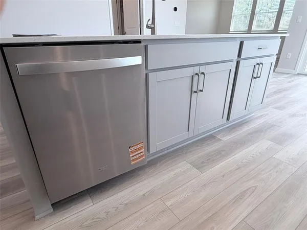 a kitchen with a sink and wooden floor