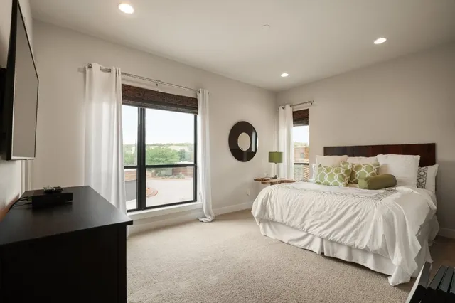 a bedroom with a bed and a large window