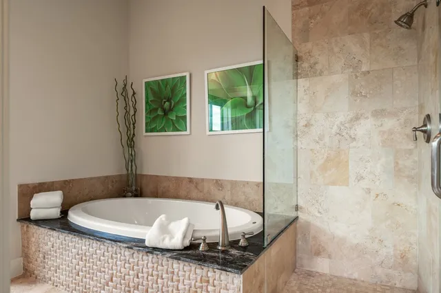 a bathroom with a granite countertop bathtub and shower