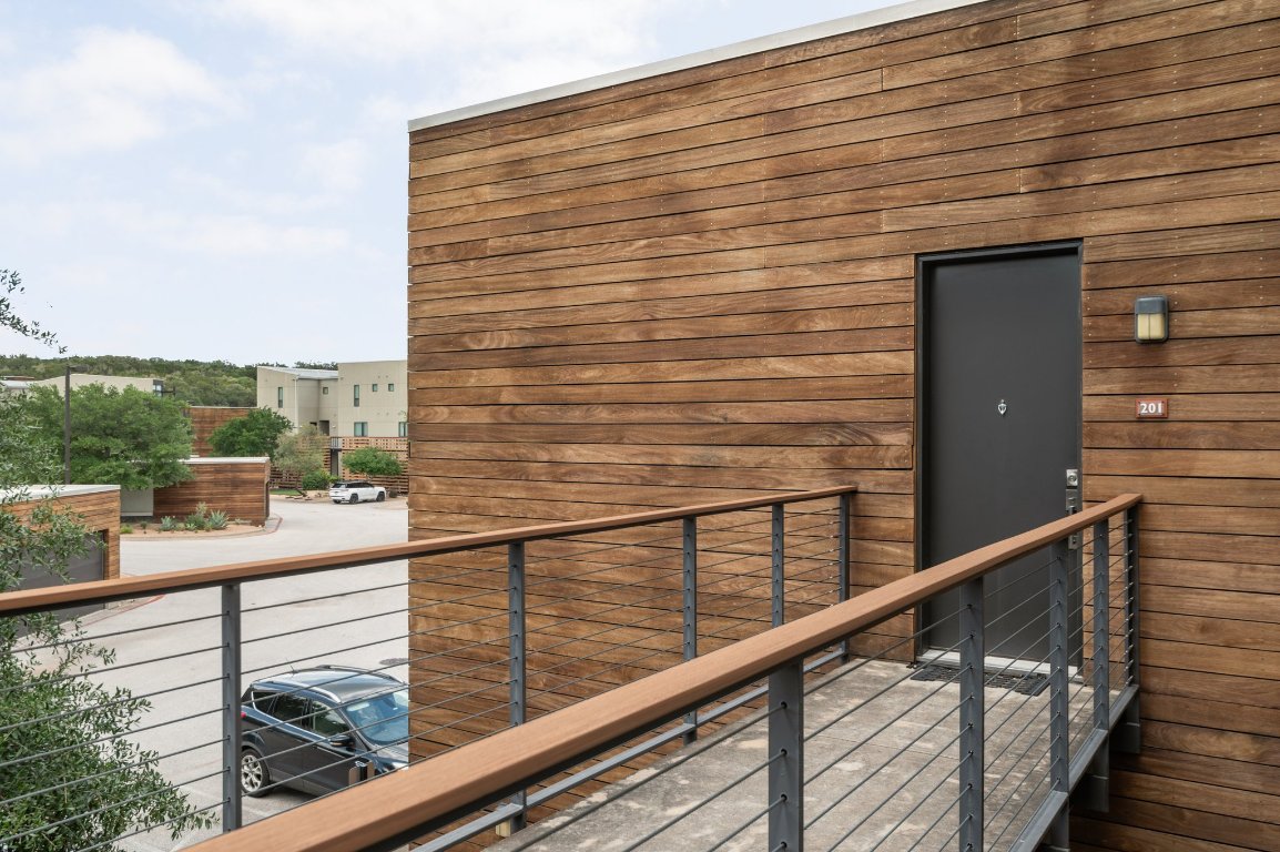 1101 Ivean Pearson Road, Unit E201 Leander, TX 78645 - Photo 19 of 20 a view of a balcony with a floor to ceiling window and wooden floor