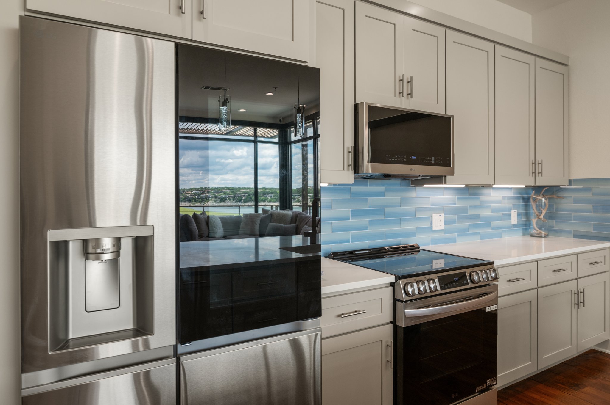 1101 Ivean Pearson Road, Unit E201 Leander, TX 78645 - Photo 6 of 20 Kitchen with appliances with stainless steel finishes, backsplash, light countertops, and dark wood-type flooring