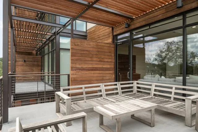a view of a balcony with dining table and chairs