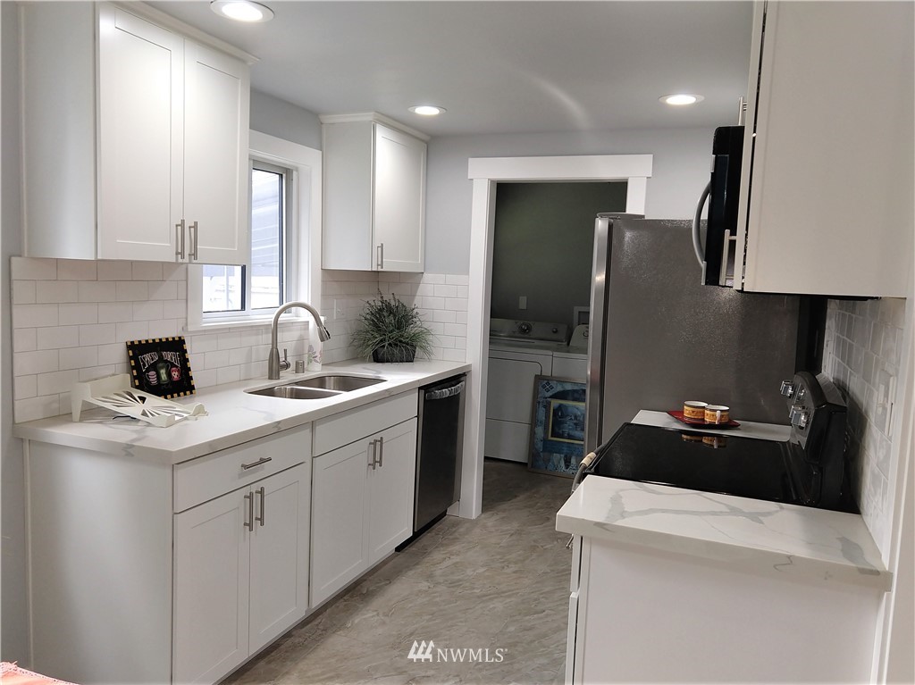 3201 Southeast 5th Street Renton, WA 98058 - Photo 8 of 17 a kitchen with a sink a stove and refrigerator