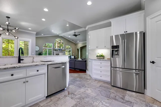 a kitchen with white cabinets and stainless steel appliances