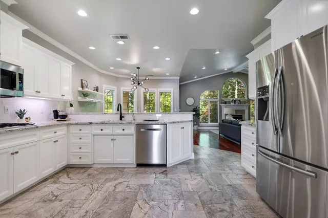 a kitchen with stainless steel appliances granite countertop refrigerator sink and stove