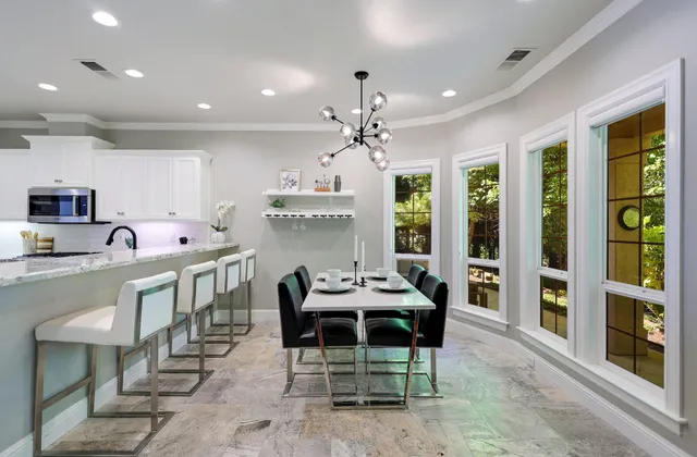 a kitchen with stainless steel appliances kitchen island granite countertop a table and chairs in it