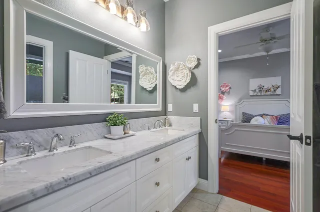 a bathroom with a granite countertop double vanity and a mirror
