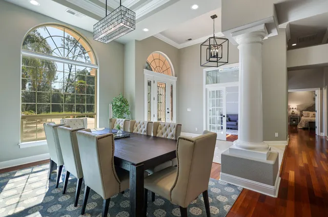 a view of a dining room with furniture a chandelier and wooden floor