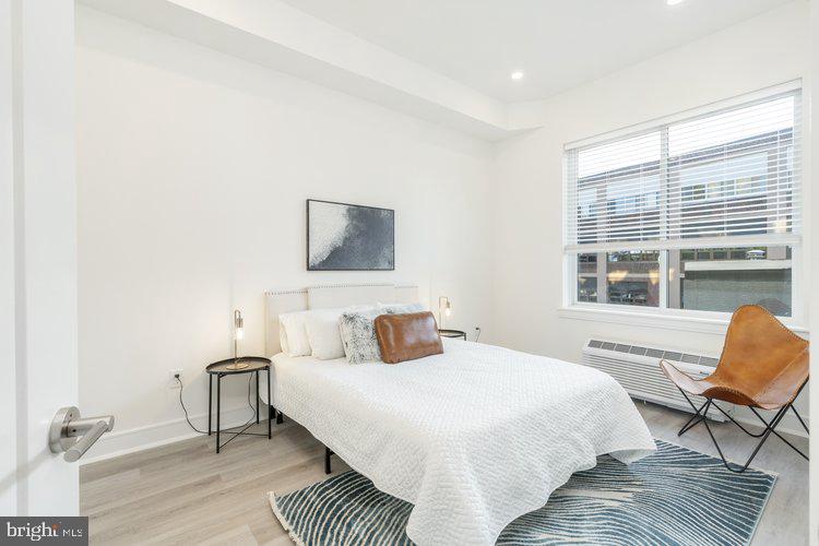 4550 Mitchell Street, Unit 208 Philadelphia, PA 19128 - Photo 11 of 25 a bedroom with a bed a chair and a large window