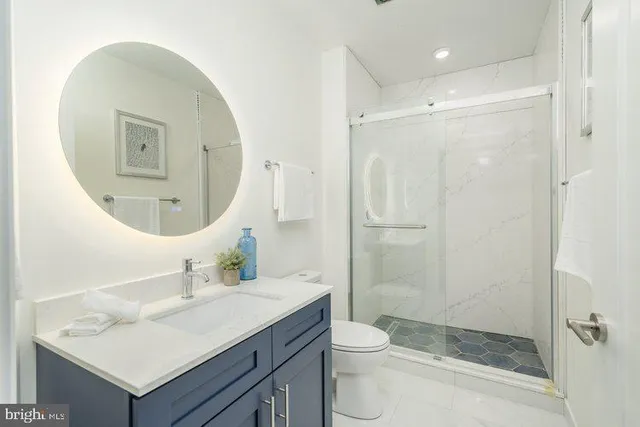 a bathroom with a sink a toilet and shower