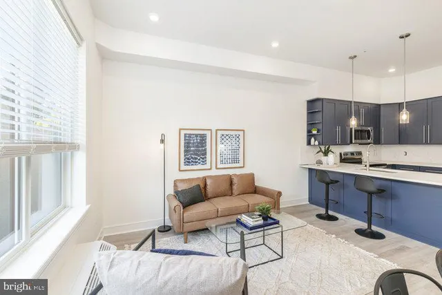 a living room with furniture a couch and kitchen view