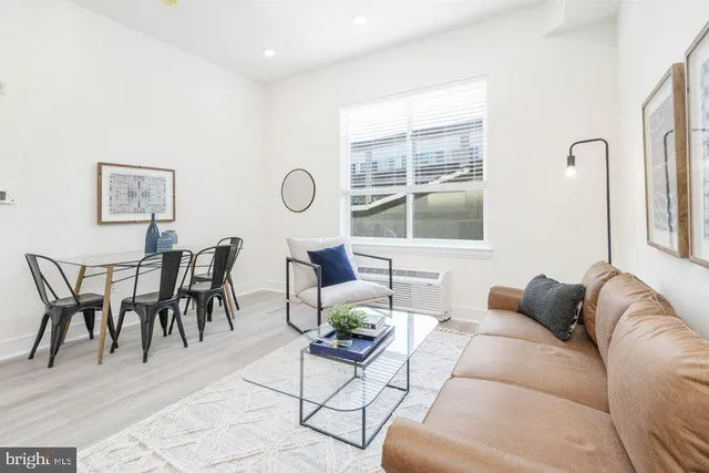 a living room with furniture a table and a large window