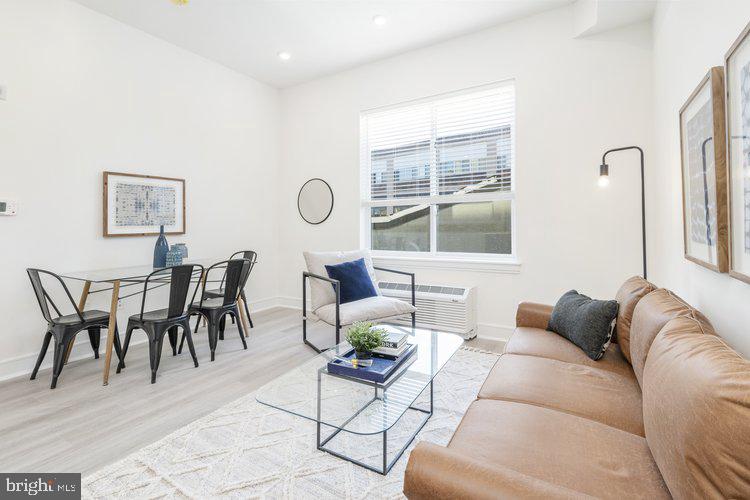 4550 Mitchell Street, Unit 208 Philadelphia, PA 19128 - Photo 7 of 25 a living room with furniture a table and a large window