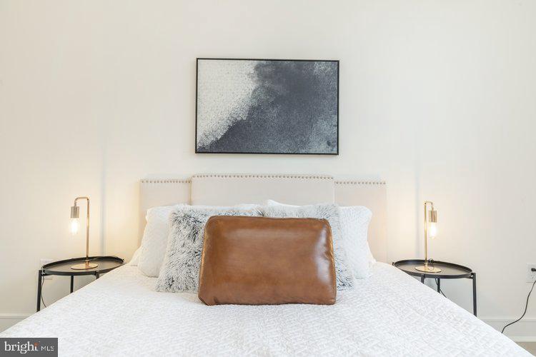 4550 Mitchell Street, Unit 208 Philadelphia, PA 19128 - Photo 10 of 25 a bedroom with a bed and a lamp on table