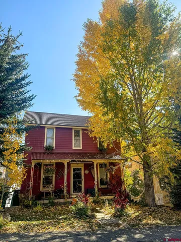 a view of a big house with large trees and windows