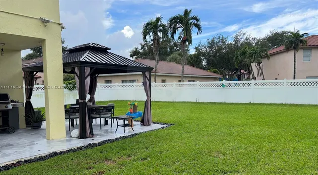 a view of a house with backyard and sitting area