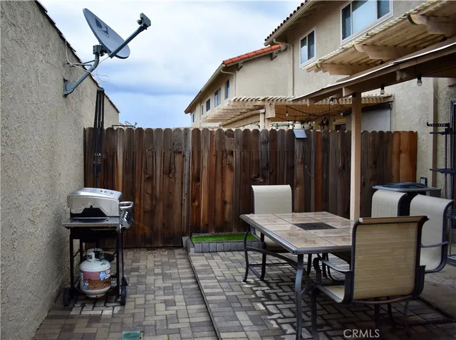 a backyard of a house with barbeque oven table and chairs