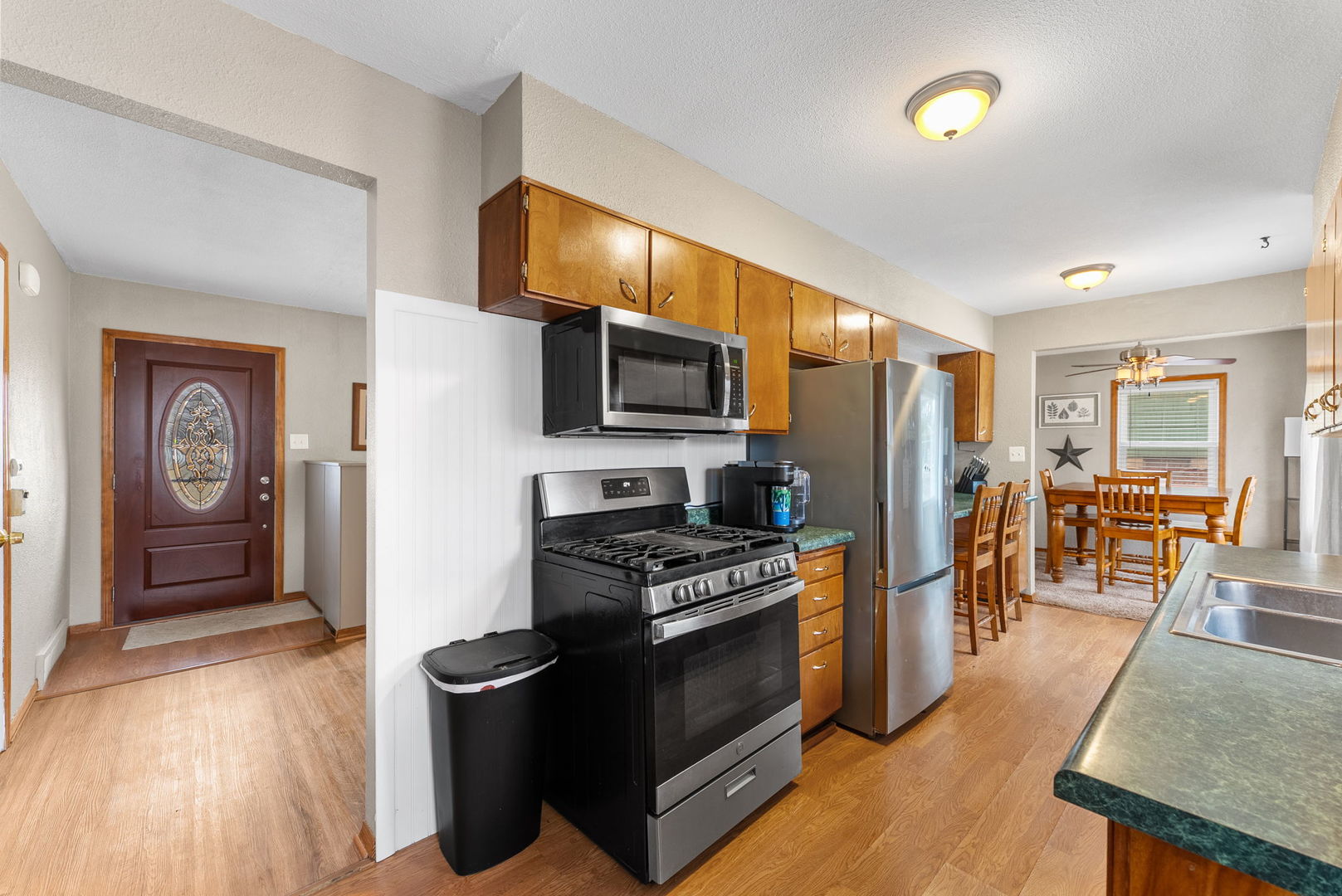 1135 5th Avenue North Clinton, IA 52732 - Photo 11 of 22 a kitchen with stainless steel appliances granite countertop a stove top oven a sink dishwasher a dining table and chairs with wooden floor