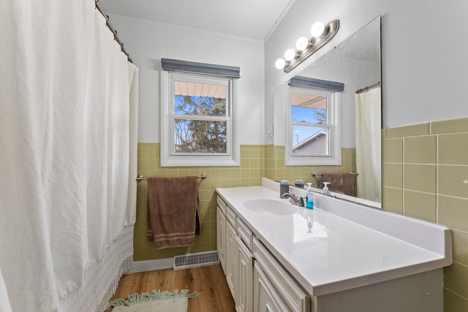 1135 5th Avenue North Clinton, IA 52732 - Photo 12 of 22 a bathroom with a sink a mirror and a shower