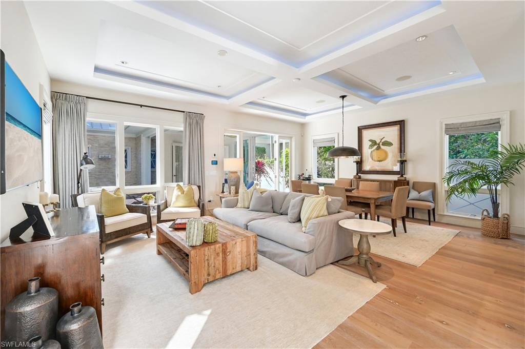 42 6th Street South Naples, FL 34102 - Photo 2 of 46 Living room featuring light wood-type flooring, coffered ceiling, and healthy amount of natural light
