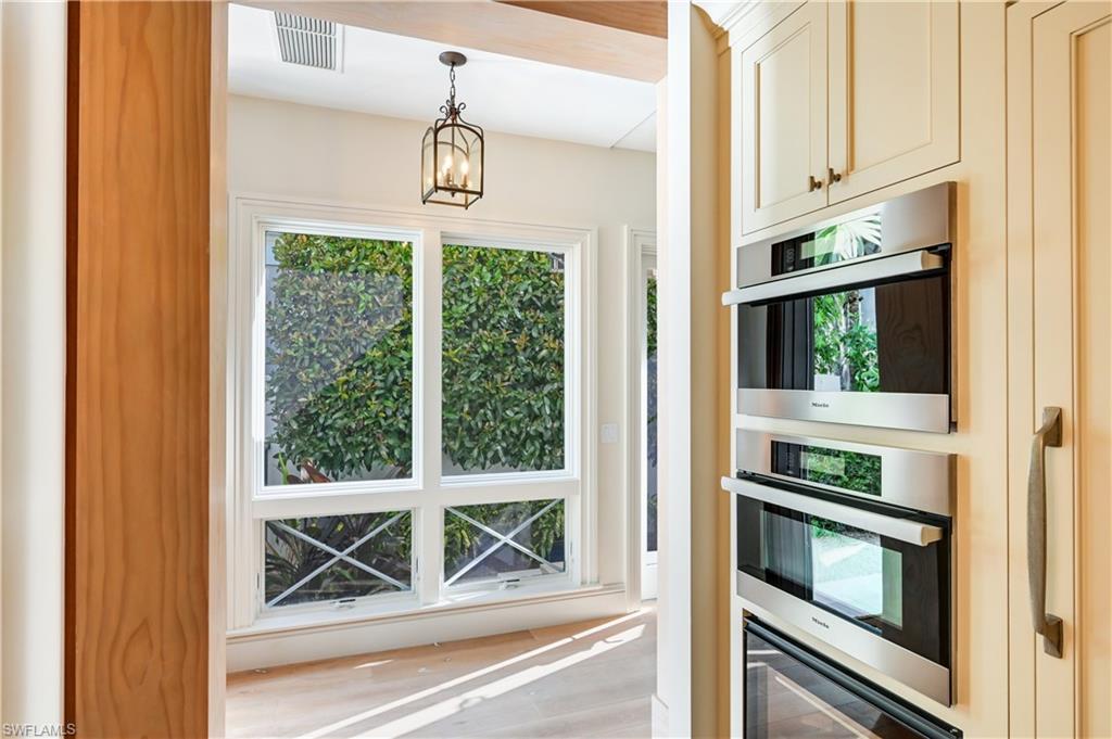 42 6th Street South Naples, FL 34102 - Photo 27 of 46 Kitchen featuring hanging lights and stainless steel appliances