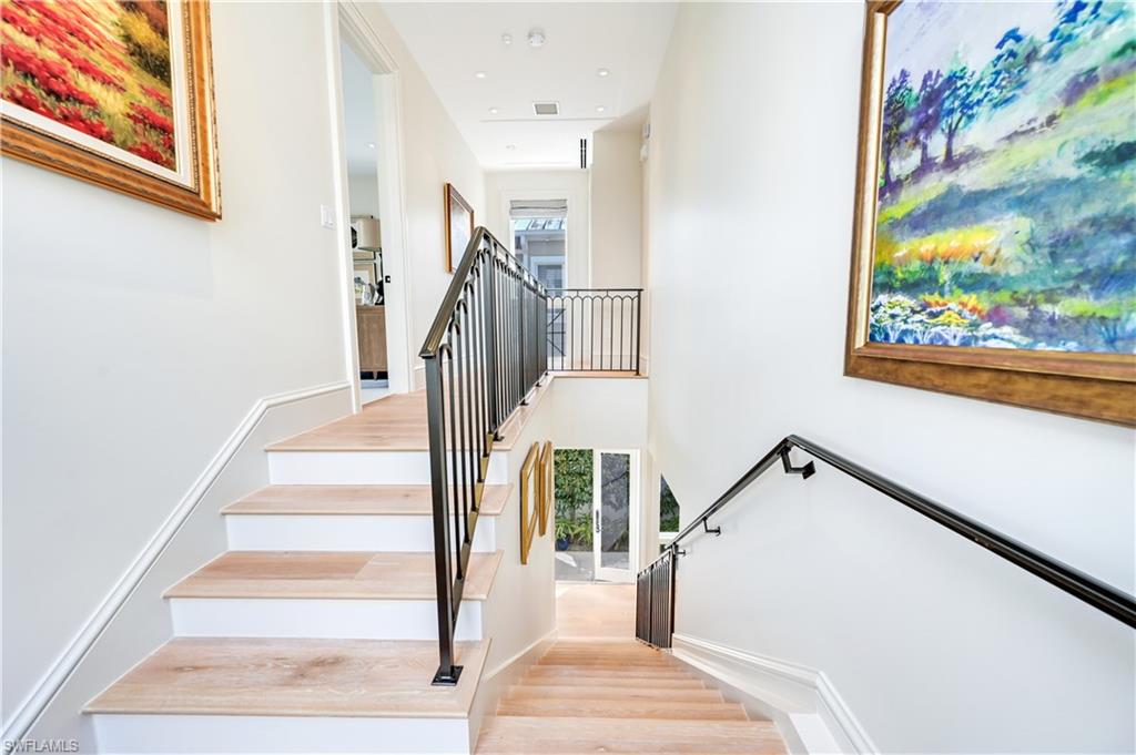 42 6th Street South Naples, FL 34102 - Photo 30 of 46 Stairway with wood finished floors, a high ceiling, and recessed lighting