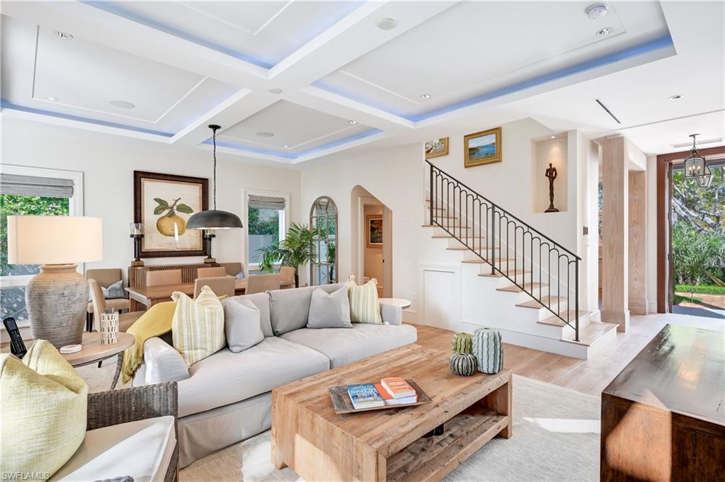 42 6th Street South Naples, FL 34102 - Photo 3 of 46 Living room with healthy amount of natural light, coffered ceiling, wood finished floors, and arched walkways