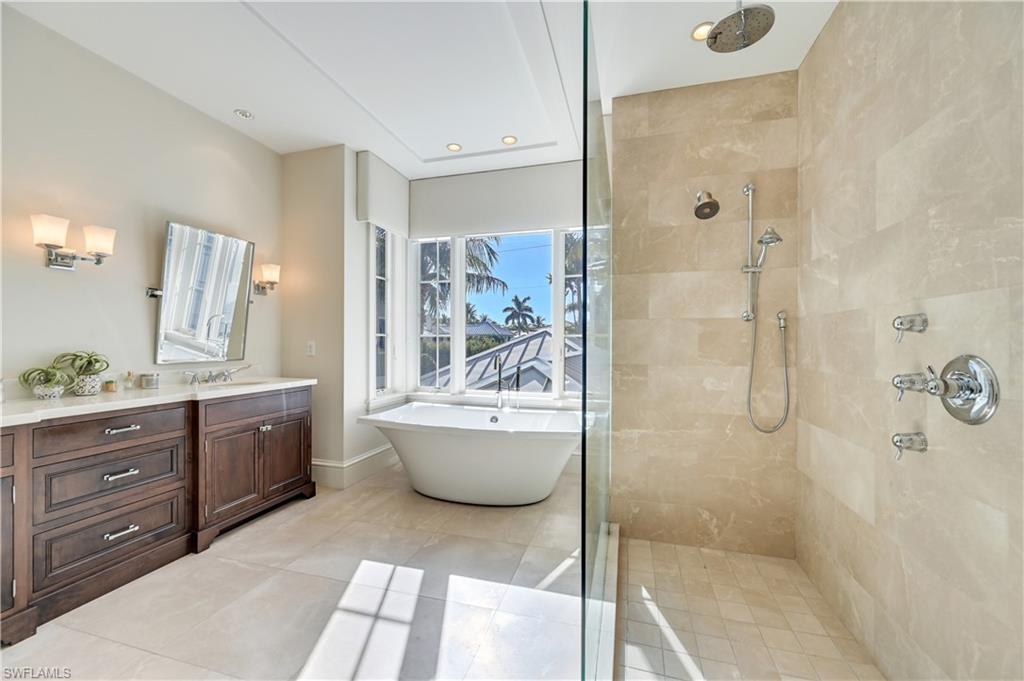 42 6th Street South Naples, FL 34102 - Photo 37 of 46 Bathroom featuring tiled shower, vanity, a freestanding bath, recessed lighting, and light tile patterned flooring