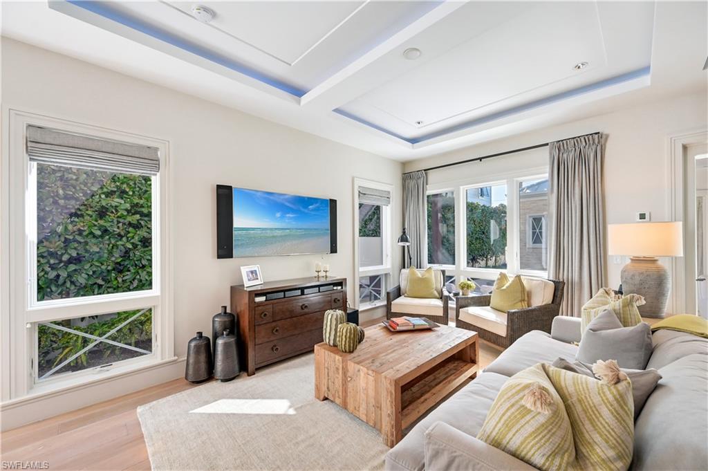 42 6th Street South Naples, FL 34102 - Photo 4 of 46 Living room with a tray ceiling and wood finished floors