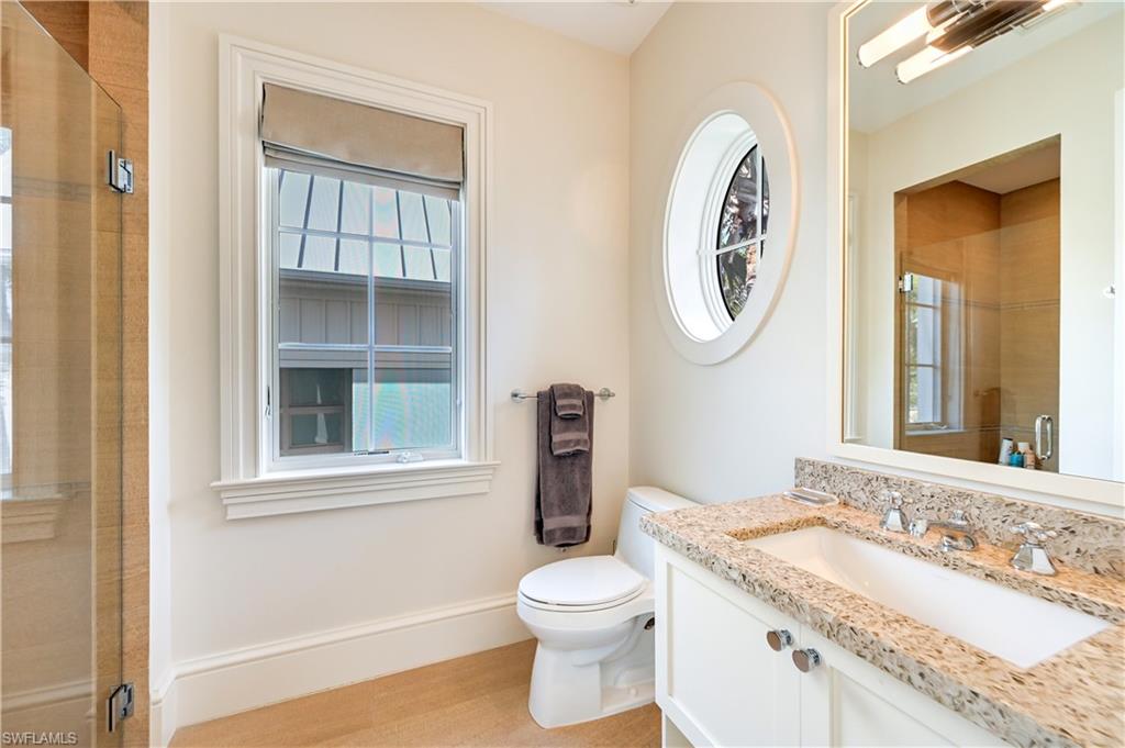 42 6th Street South Naples, FL 34102 - Photo 42 of 46 Full bathroom with a stall shower, vanity, and light wood finished floors