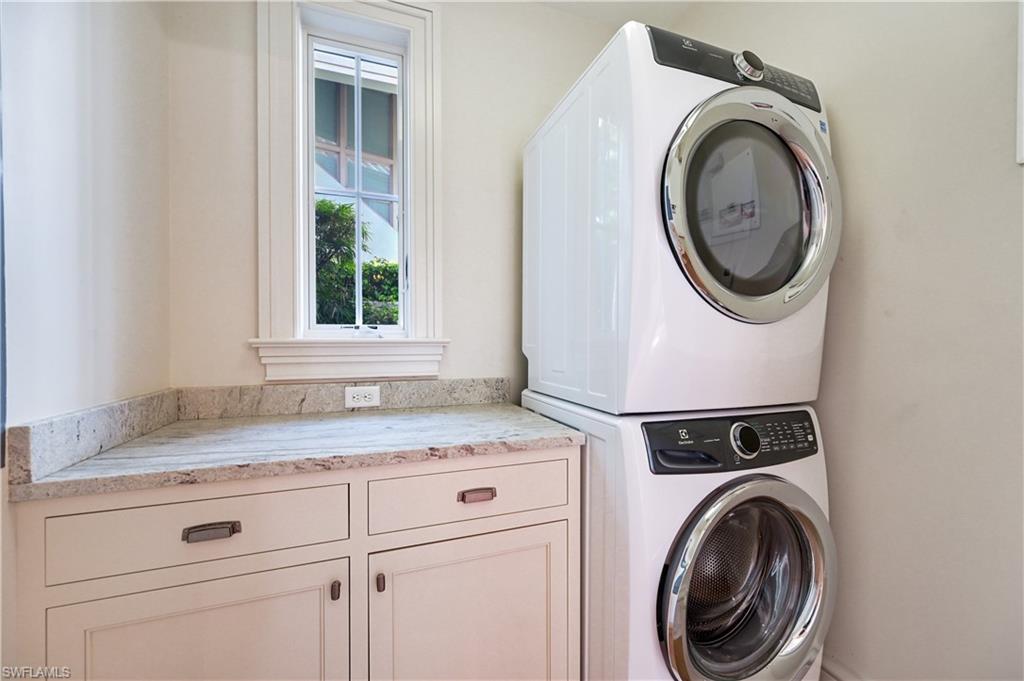 42 6th Street South Naples, FL 34102 - Photo 43 of 46 Laundry room with stacked washer / drying machine and cabinet space