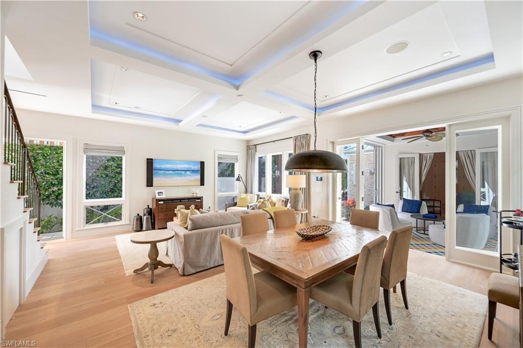 42 6th Street South Naples, FL 34102 - Photo 5 of 46 Dining space featuring light wood-style floors, coffered ceiling, plenty of natural light, ceiling fan, and a raised ceiling