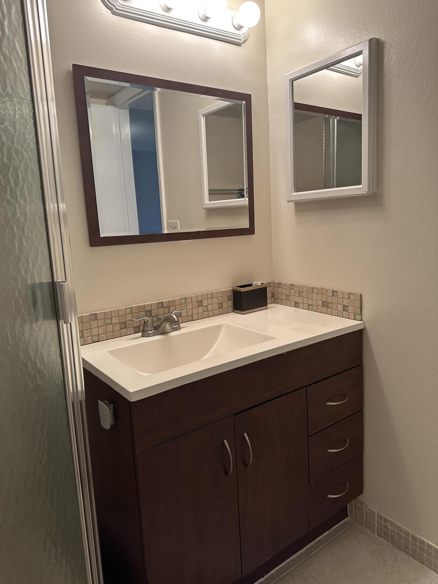 9355 Southwest 8th Street, Unit 311 Boca Raton, FL 33428 - Photo 14 of 17 a bathroom with a sink and a mirror