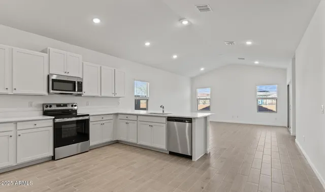 a kitchen with stainless steel appliances a refrigerator sink and microwave